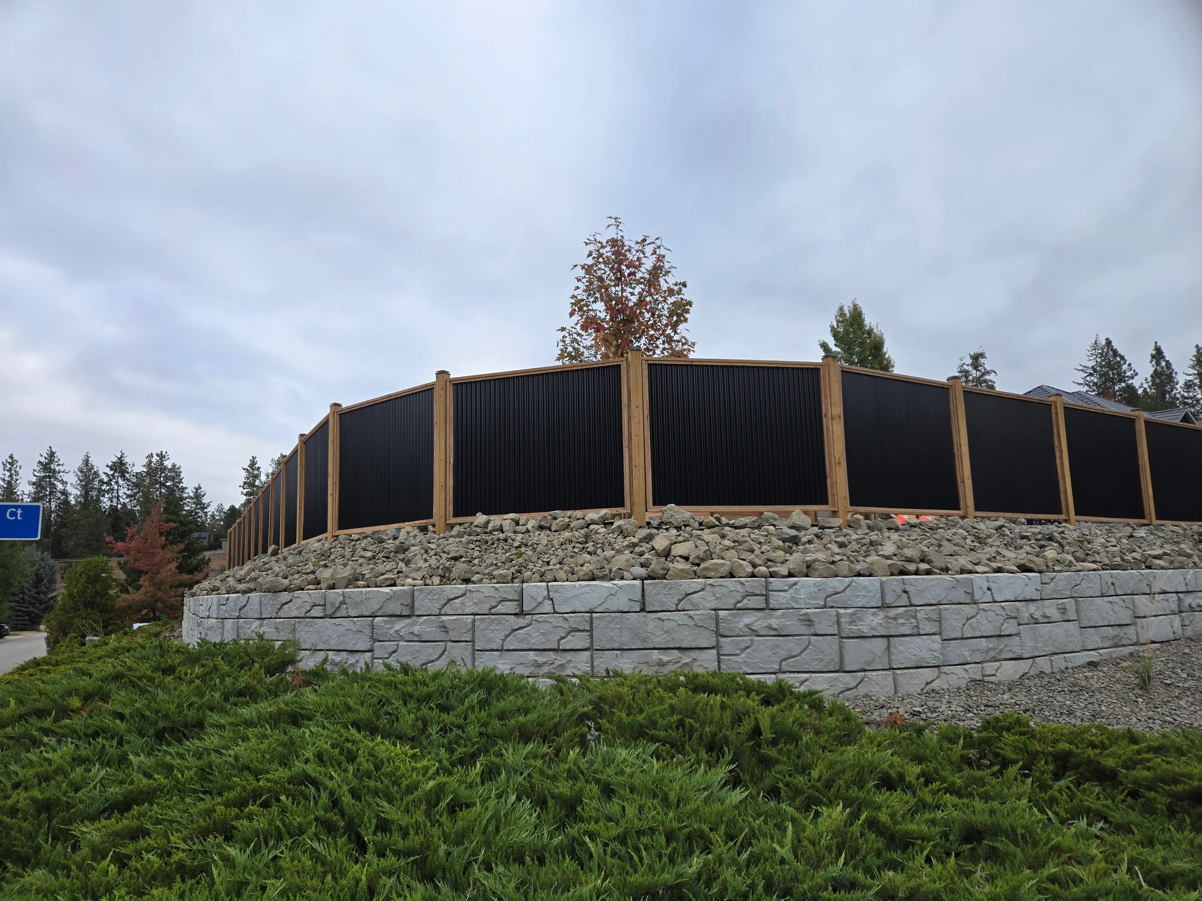 Wooden fence with shrubs done by sweet yards landscaping in Kelowna